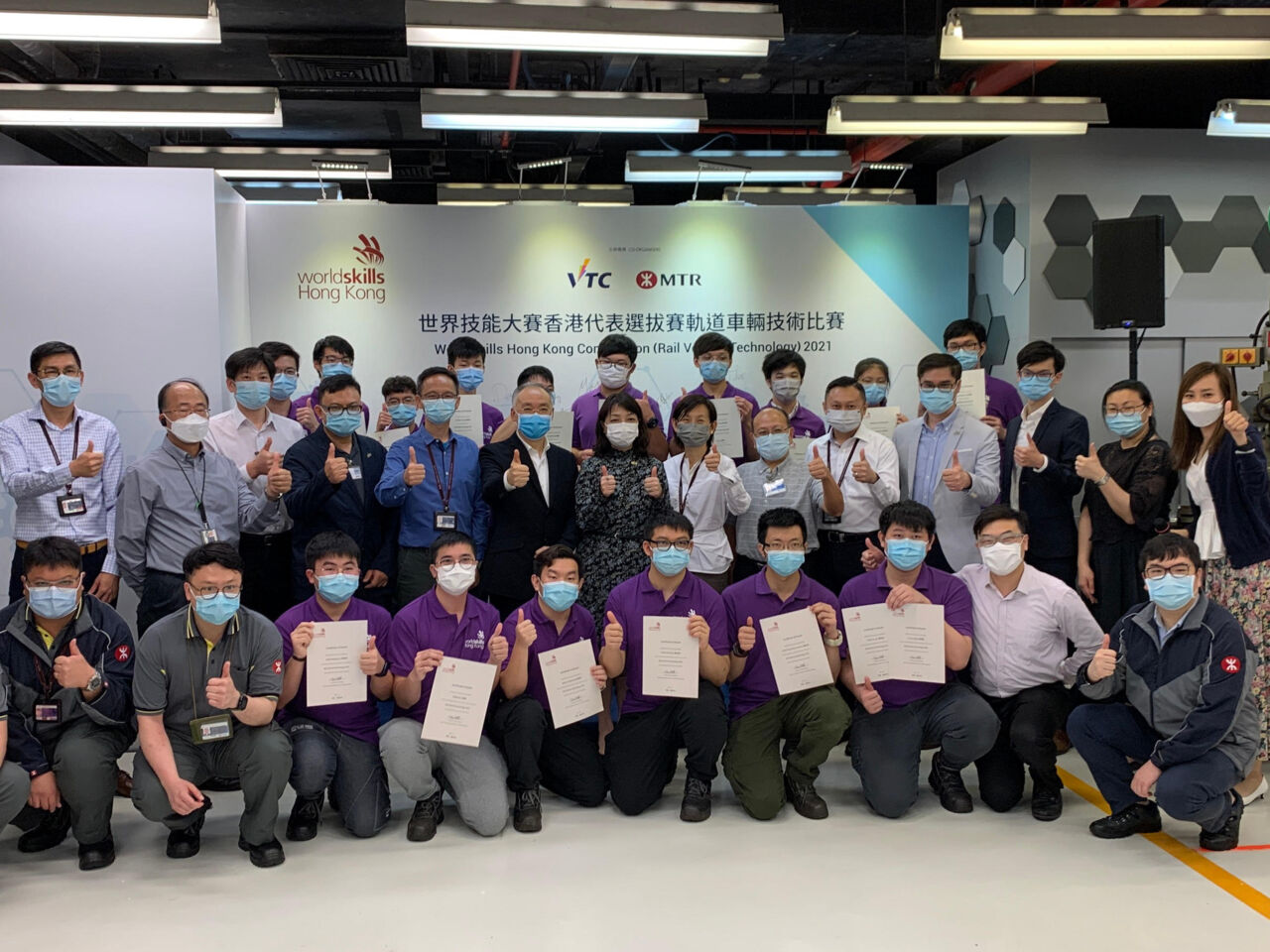 竞争对手和专家在2021年5月香港轨道车辆技术竞赛结束时摆出证书。