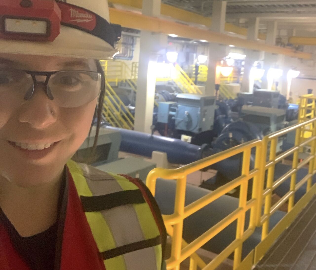 迪安娜·雷诺兹（Deanna Reynolds）是加拿大少数几位经过认证的女性工业机械师米尔赖特（Millwrights）之一，他在背景中拥有一台大型机器。